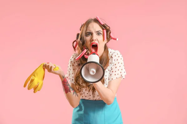 Funny housewife with megaphone on color background — Stock Photo, Image