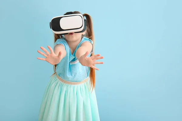 Маленька дівчинка з окулярами віртуальної реальності на кольоровому фоні — стокове фото