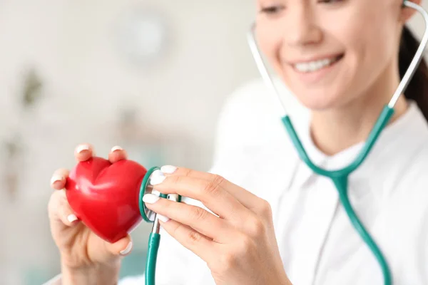 Cardióloga femenina con corazón rojo en clínica moderna — Foto de Stock