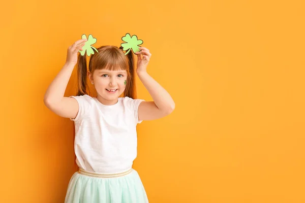 Funny little girl with clover on color background. St. Patrick's Day celebration — Stock Photo, Image