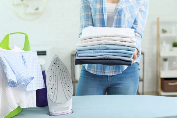Schöne junge Hausfrau mit Wäsche zu Hause — Stockfoto