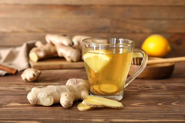 Cup of healthy drink with lemon and ginger on wooden table — Stock Photo, Image
