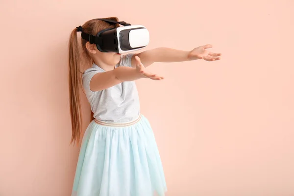 Little girl with virtual reality glasses on color background — Stock Photo, Image