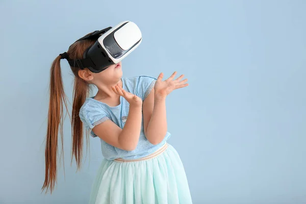 Niña con gafas de realidad virtual sobre fondo de color — Foto de Stock