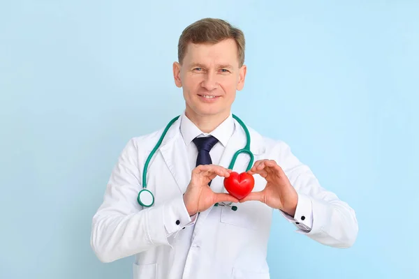 Mężczyzna kardiolog na tle koloru — Zdjęcie stockowe