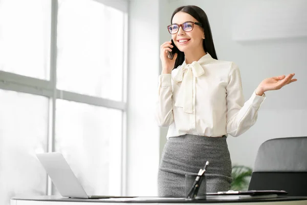 Female accountant talking by phone in office — Stock Photo, Image