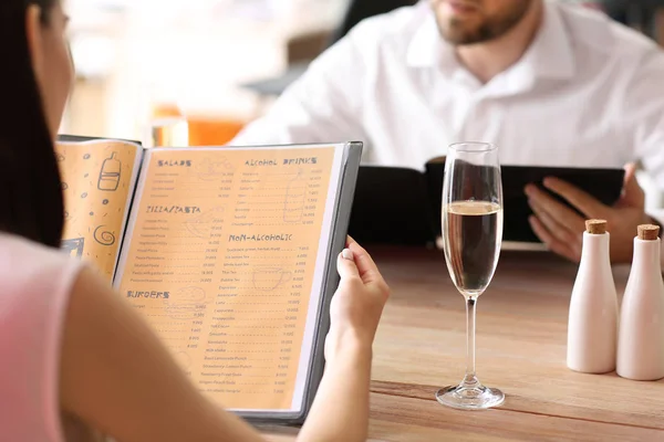 Jovem casal com menu sentado no restaurante — Fotografia de Stock