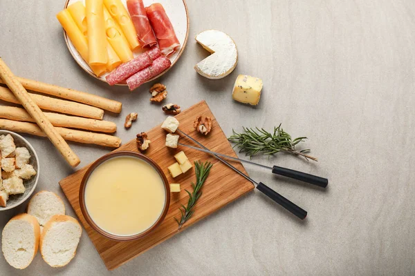 Fondue de queso con snacks sobre fondo gris —  Fotos de Stock