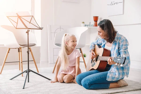 Privat musiklärare ger gitarrlektioner till liten flicka hemma — Stockfoto