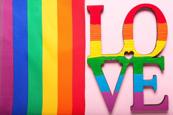 Drapeau arc-en-ciel avec mot LOVE sur fond couleur. Concept LGBT — Photo