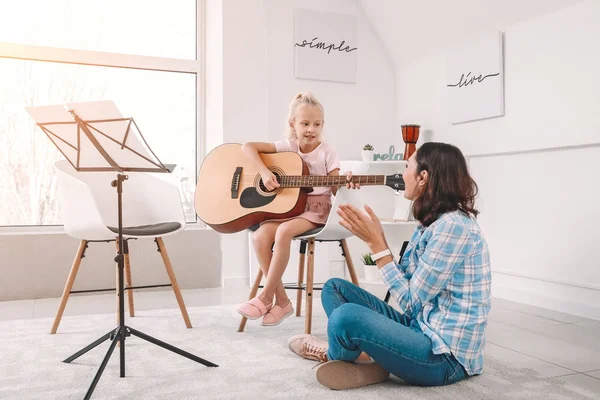 Privat musiklärare ger gitarrlektioner till liten flicka hemma — Stockfoto