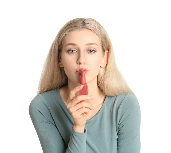 Beautiful young woman applying makeup on white background — Stock Photo, Image