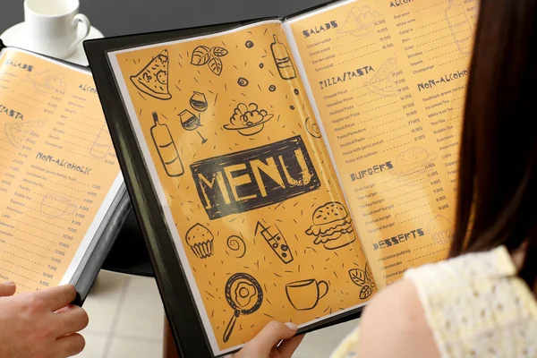 Młoda para z menu w restauracji, zbliżenie — Zdjęcie stockowe