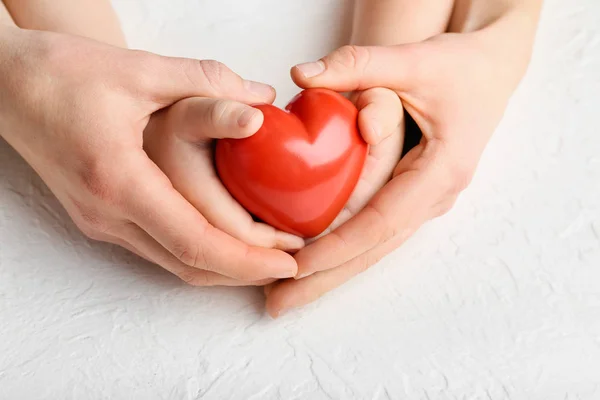 Ręce kobiety i dziecka z czerwonym sercem na białym tle. Koncepcja kardiologii — Zdjęcie stockowe