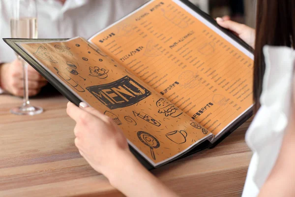 Jeune femme avec menu assis au restaurant, gros plan — Photo