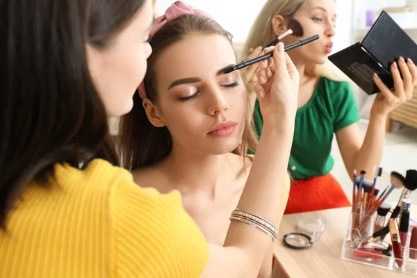 Krásné mladé ženy, které používají make-up společně doma — Stock fotografie