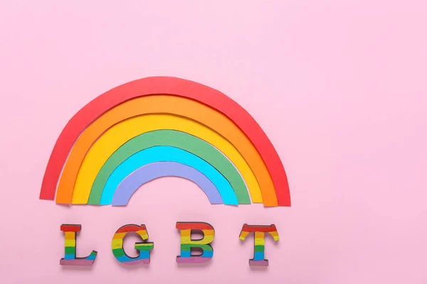 Листи ЛГБТ з паперовою веселкою на кольоровому фоні — стокове фото