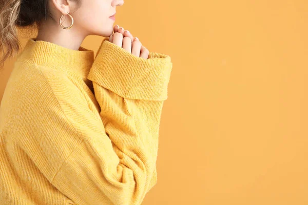 Mooie jonge vrouw in warme trui op kleur achtergrond — Stockfoto