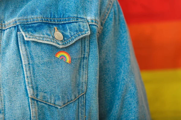 Person with pinned rainbow badge as a symbol of LGBT, closeup