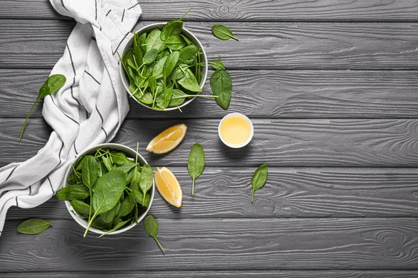 Bowls with fresh spinach on wooden background — Stock Photo, Image