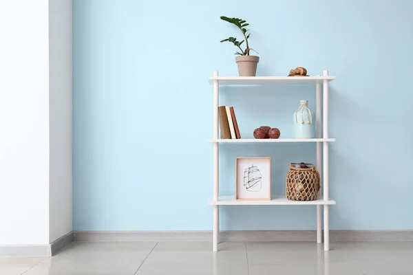 Shelf unit with decor near color wall — Stock Photo, Image