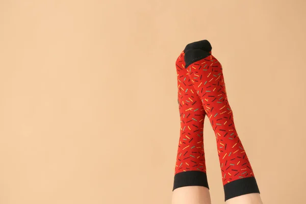 Beine der jungen Frau in Socken auf farbigem Hintergrund — Stockfoto
