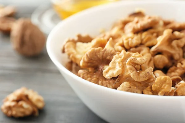 Bowl with tasty walnuts on table, closeup — Stock Photo, Image