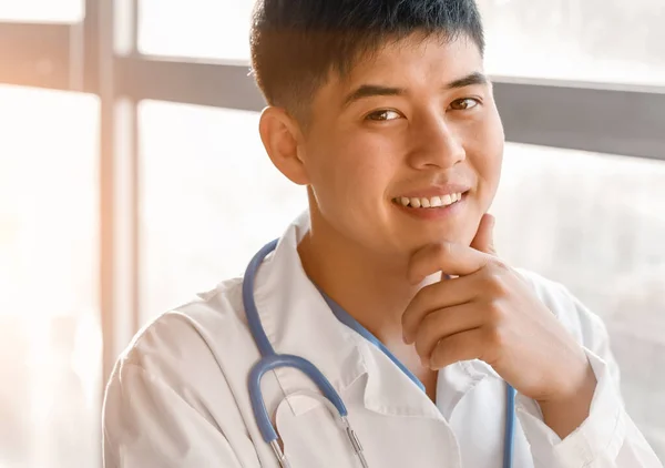 Мужчина азиатский врач у окна в клинике — стоковое фото
