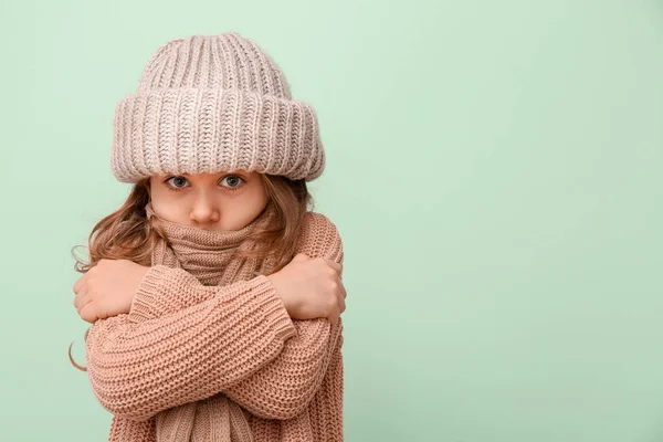 Cute little girl in winter clothes on color background — Stock Photo, Image