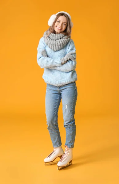 Belle jeune femme sur patins à glace sur fond de couleur — Photo