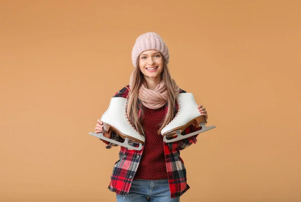 Vacker ung kvinna med skridskor på färg bakgrund — Stockfoto