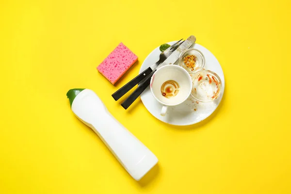 Грязные пустые блюда с моющим средством и губкой на цветном фоне — стоковое фото