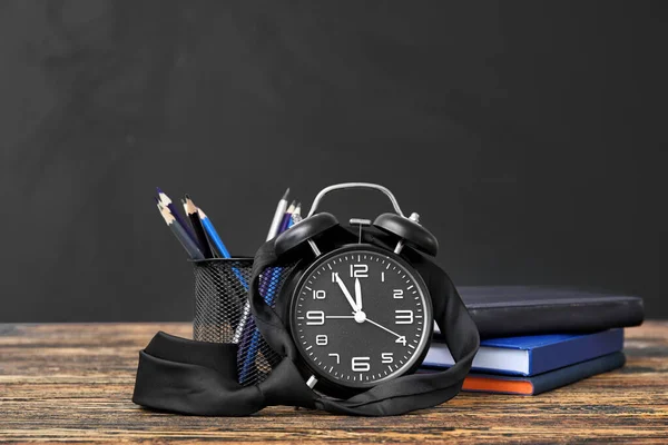 Conjunto de papelería escolar y reloj en la mesa en el aula —  Fotos de Stock