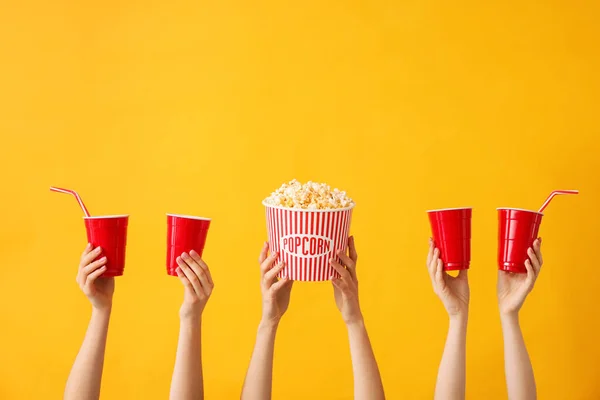 Viele Hände mit Popcorn und Getränkebechern auf farbigem Hintergrund — Stockfoto