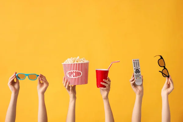 Viele Hände mit Popcorn, Getränk, Fernbedienung und Brille auf farbigem Hintergrund — Stockfoto