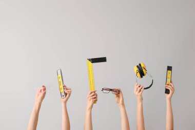 Gri arka planda mimarın malzemeleriyle pek çok el.