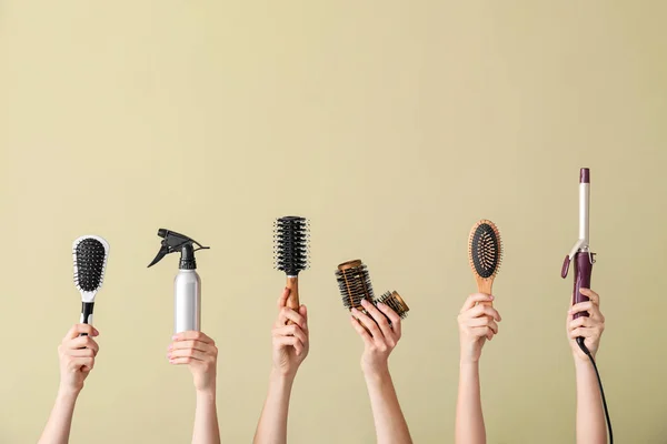 Many hands with hairdresser's supplies on color background — Stock Photo, Image