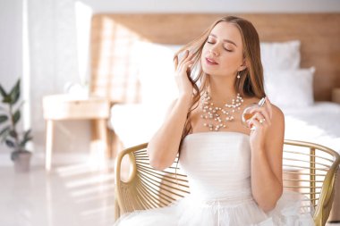 Evde parfüm şişesi ile güzel genç gelin