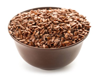 Beyaz arkaplanda keten tohumları olan bir kase