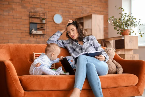 Gespannen moeder met haar baby werken thuis — Stockfoto