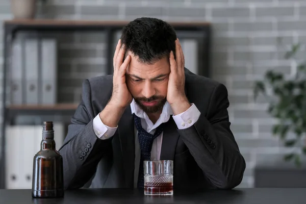 Empresario bebiendo coñac en la oficina. Concepto de alcoholismo — Foto de Stock