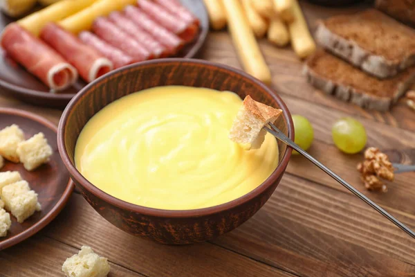 Inmersión de crouton en fondue de queso en la mesa —  Fotos de Stock