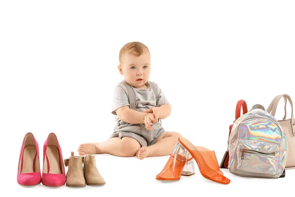 Bébé mignon avec des chaussures et des sacs féminins élégants sur fond blanc — Photo
