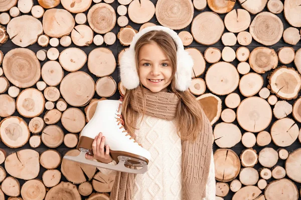 Carina bambina con pattini da ghiaccio su sfondo di legno — Foto Stock