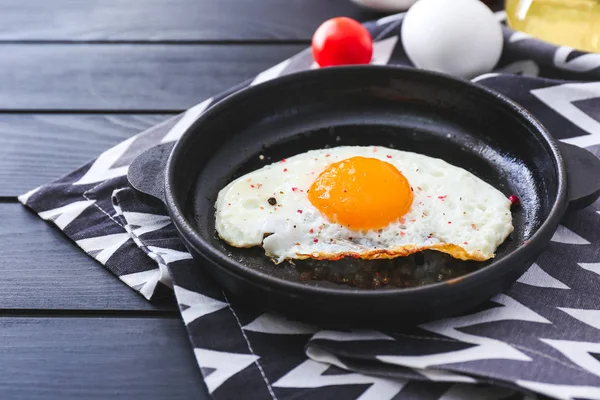 Frying pan with tasty egg on table — Stock Photo, Image