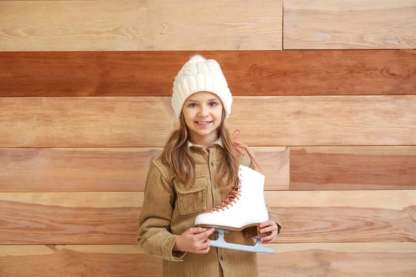 Linda niña con patines de hielo sobre fondo de madera — Foto de Stock