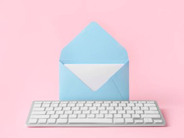 Renkli arka planda zarf ve bilgisayar klavyesi. Kağıt posta e-postaya karşı