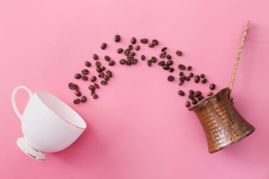 Kahve fincanı, kahve çekirdeği ve renkli fonda jezve.