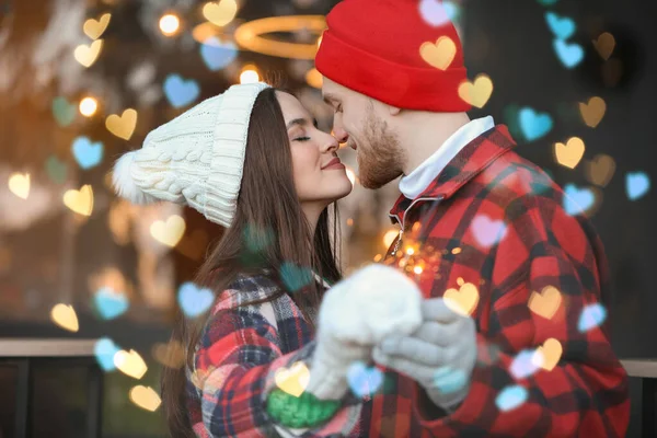 Glada unga par med jul tomtebloss utomhus på vinterdagen — Stockfoto