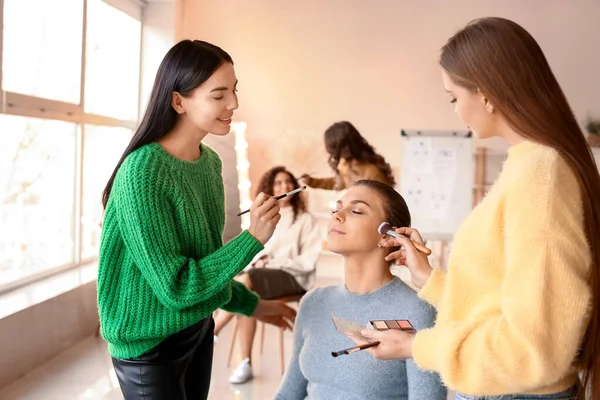 化粧学校で学生を教える若い女性 — ストック写真
